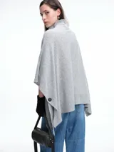 Poncho amplio de cuello alto, confeccionado en hilado con lana y cashmere, con diseño de caída recta y botones laterales.