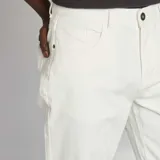 Pantalón chino de hombre, color blanco crudo, de corte slim y tiro medio, con cinco bolsillos y cierre de cremallera.