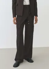 Pantalon cargo de corte recto y tiro medio, confeccionado en tejido fluido. Presenta cintura elástica con cordón ajustable, bolsillos laterales y bolsillos de parche con solapa en las piernas.