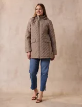 Campera capitoneada de corte largo con diseño acolchado en forma de rombos. Cuenta con cierre frontal completo, capucha desmontable, bolsillos delanteros con solapa y cierre, y forro interno a tono.