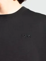 Remera negra de manga corta, cuello redondo y corte holgado, con el logo de Diesel bordado en el pecho.
