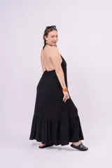 Vestido largo negro con escote en V, breteles finos y falda amplia con volado en el ruedo.