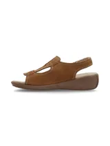 Sandalias Hush Puppies modelo Juliana Tan, de cuero color marrón tostado con detalles de perforaciones láser en el empeine, costuras visibles y cierre con tiras autoadheribles. Cuenta con suela de goma con plataforma baja tipo cuña.