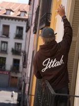 Hoodie de color marrón con capucha y estampado tipográfico en color blanco en la espalda.