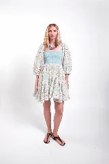 Vestido corto de encaje celeste y crudo, con cuerpo superior fruncido y elastizado, escote cuadrado, mangas abullonadas y falda con volados.