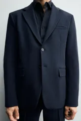 Blazer de corte slim fit confeccionada en tejido con viscosa, con cuello de solapas de muesca, manga larga con puños abotonados, bolsillo de vivo en el pecho, bolsillos con solapa en la cadera y cierre frontal con botones.