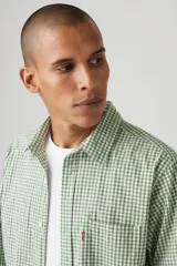 Camisa a cuadros verde y blanco con bolsillo en el pecho y logo de la marca en rojo.