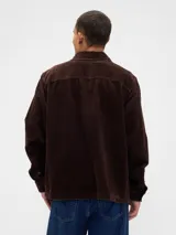 Sobrecamisa de pana color verde oliva, con cuello clásico, cierre frontal de botones y dos bolsillos delanteros con solapa.