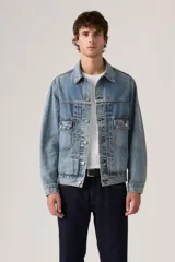 Campera de denim azul con lavado medio, diseño clásico de trucker con bolsillos delanteros con solapa y botones metálicos.