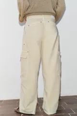Jeans de tiro medio con diseño cargo, bolsillos de plastrón y pernera holgada que se estrecha hacia el tobillo. Cierre frontal con cremallera y botón.
