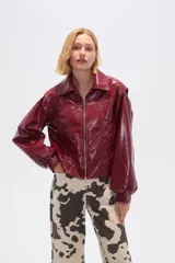 Chaqueta de eco-cuero color bordó, holgada, con cierre frontal, cuello tipo camisa y bolsillos laterales.