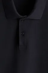 Remera polo de manga corta en piqué de algodón color negro, con cuello clásico y tapeta de dos botones. Corte estándar para una silueta clásica y cómoda.