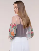 Cardigan tipo kimono largo de tul blanco semitransparente, con frente abierto y mangas largas. Presenta vistosos bordados florales multicolor en mangas, dobladillo y laterales.