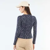 Camiseta de manga larga en tejido de punto acanalado color azul marino con estampado floral pequeño en tonos rosados. Presenta cuello redondo con cierre frontal de botones tipo henley.
