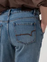 Pantalón de jean tiro alto y pierna recta, confeccionado en denim azul. Presenta diseño clásico estilo carpintero con trabilla lateral para herramientas y bolsillos diagonales.