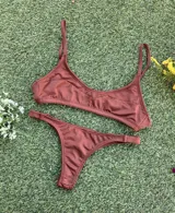 Conjunto de bikini color chocolate confeccionado en tela morley texturada. El top es tipo deportivo con breteles finos y el corpiño cuenta con aberturas para tazas soft. La bombacha es de corte colaless.