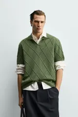 Polo regular fit verde de punto de algodón, con cuello solapa, abertura frontal y diseño de calados geométricos en rombos.