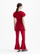 Pantalon de tejido de punto color rojo, con ajuste al cuerpo y botamanga ancha tipo oxford con detalle de pliegues verticales.