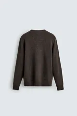 Cárdigan de punto en color verde oscuro, con cuello en pico, manga larga y cierre frontal con botones. Presenta acabados en rib en puños y bajo.