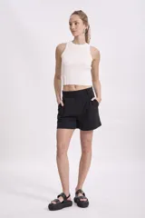 Short negro de vestir con pliegues frontales y bolsillos laterales.