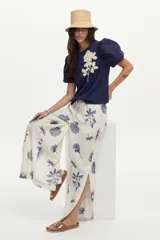Blusa azul marino de algodón, con mangas abullonadas cortas de tela plana y gran bordado de rosa en tono crudo en el pecho.