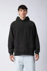 Buzo canguro con capucha, de corte oversize y efecto gastado. Presenta recortes horizontales en el pecho y puños acanalados.
