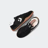 Championes Converse Run Star Trainer negros con detalles en blanco y suela de goma color caramelo.