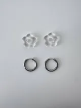 Aros de acero quirúrgico argolla con dije colgante en forma de flor de resina color gris marmoleado.