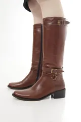 Bota de caña alta de cuero liso negro, con diseño clásico, detalles de hebillas metálicas, cierre lateral y taco bajo.