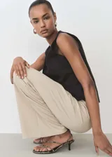 Pantalon wide leg de tiro alto, confeccionado en tejido fluido con cintura elástica y lazo ajustable.