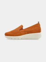 Mocasines slip-on de cuero nobuck color suela con diseño perforado en el empeine, elásticos laterales para facilitar el calce y suela plataforma de poliuretano blanca.