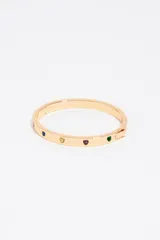 Pulsera rígida plateada con cierre de bisagra, decorada con incrustaciones en forma de corazón con pequeños cristales.