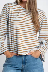 Remera de manga larga con cuello redondo, confeccionada en algodón con elastano. Presenta un diseño de rayas horizontales en color azul marino sobre fondo blanco.