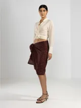 Camisa negra de manga larga con lazo en la cintura y botones nacarados. Confeccionada en 100% algodón y detalle de Polonio en cobre.