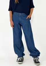 Pantalon de denim azul de corte holgado, con cintura elástica y puños ajustables con cordones en los tobillos.