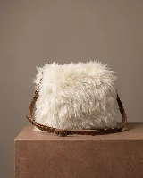 Cartera de cuero vacuno color beige con exterior de corderito sintético y correa de cuero marrón. Incluye forro y cierre.