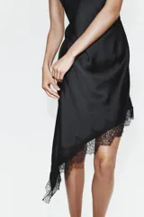 Vestido midi de satén color marrón chocolate, con escote en V, tirantes finos ajustables y bajo asimétrico decorado con encaje a tono.
