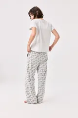 Pijama de algodón gris melange con estampado de gatos, compuesto por una remera de manga corta con cuello redondo y un pantalón largo de corte recto con cintura elástica.