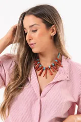 Camisa de manga larga con diseño a rayas rojas y blancas, cuello camisero y cierre frontal con solapa.