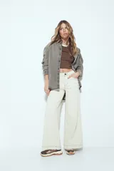 Remera cropped blanca de manga corta, con cuello redondo y terminaciones en contraste de color marrón en cuello y mangas. Inspirada en los clásicos de los años 80.