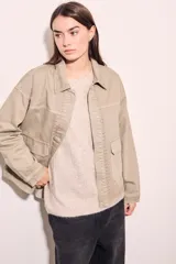 Sobrecamisa color beige de algodón con bordados en cuello, solapa, cierre y puños.