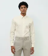 Camisa de vestir masculina de corte slim, color beige, con cuello estructurado, manga larga y cierre frontal con botones. Confeccionada con tecnología easy care para un secado rápido y menor necesidad de planchado.
