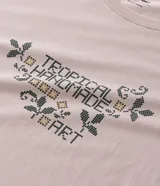 Remera de algodón color beige con cuello redondo, mangas cortas y estampa frontal con lettering y motivos botánicos.