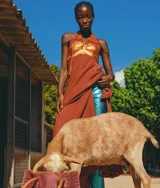 Vestido largo con pechera de cuero metalizado y falda tejida con hilo de lurex brillante. Presenta un diseño de cuello halter y corte fluido.