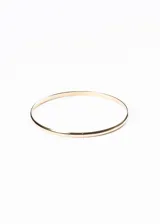 Pulsera rígida dorada, tipo brazalete, de acero quirúrgico con forma bombeada.