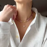 Collar de cuentas irregulares de cuarzo rosa con dije central de corazón de cuarzo rosa y herrajes con baño de oro.