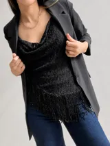 Blusa sin mangas de encaje negro con escote drapeado y bajo asimétrico adornado con flecos brillantes. Presenta breteles finos regulables y un diseño entallado.