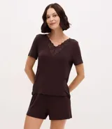 Pijama de dos piezas compuesto por una blusa de manga corta con escote en V decorado con encaje y un short con cintura elástica. Confeccionado en viscolycra, ofrece un calce suave y cómodo.