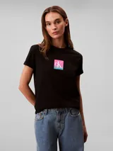 Remera Calvin Klein de algodón negro, de corte regular y manga corta con vuelta. Cuenta con cuello redondo y diseño gráfico con el monograma de la marca en un cuadro con degradado de colores rosado y celeste en el pecho.
