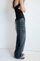 Jeans de tiro medio con corte baggy y bajo acabado en vuelta. Cuenta con trabillas, cinco bolsillos y cierre frontal con cremallera y botón metálico.
